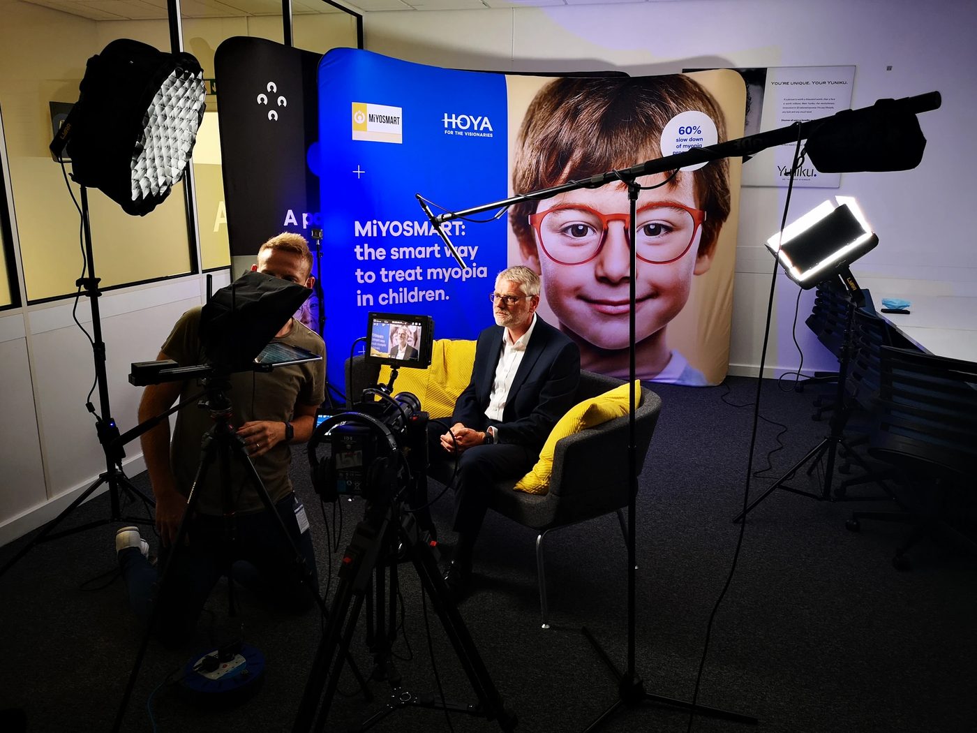 Filming a wheelchair-user interview on a theatre stage with cinema camera and boom mic