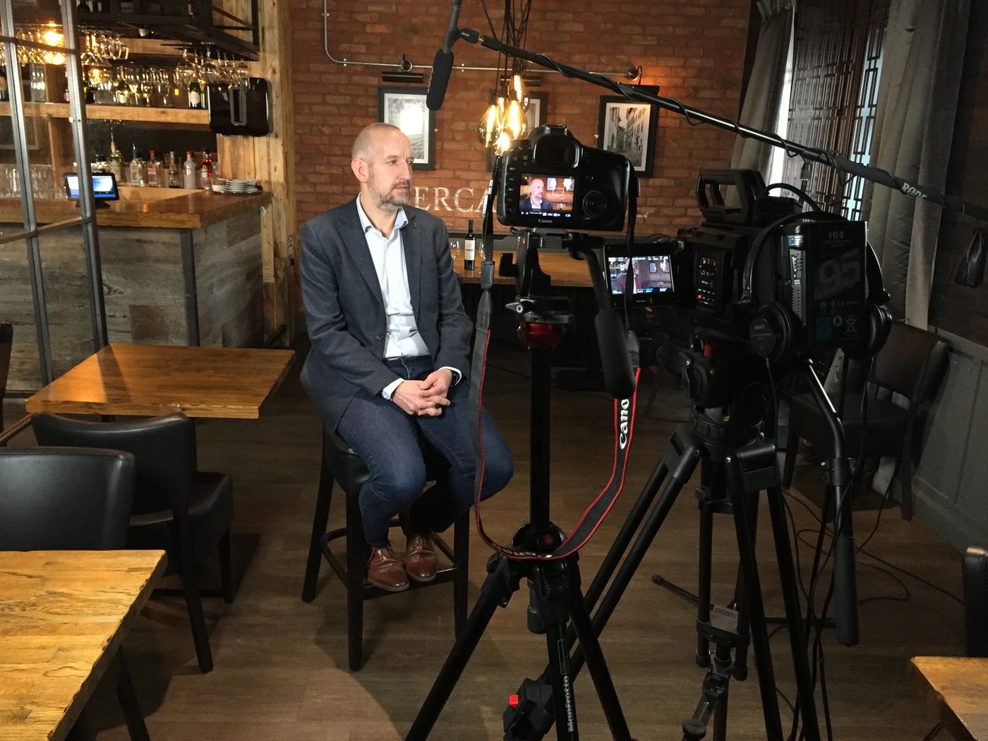 Filming a business owner interview in a warmly lit restaurant with two-camera set-up